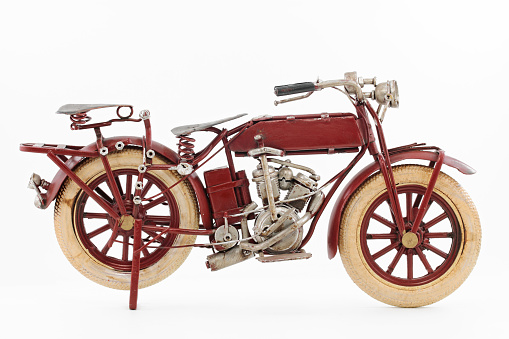 Handmade tin 1930's vintage motorcycle model, isolated over white background.