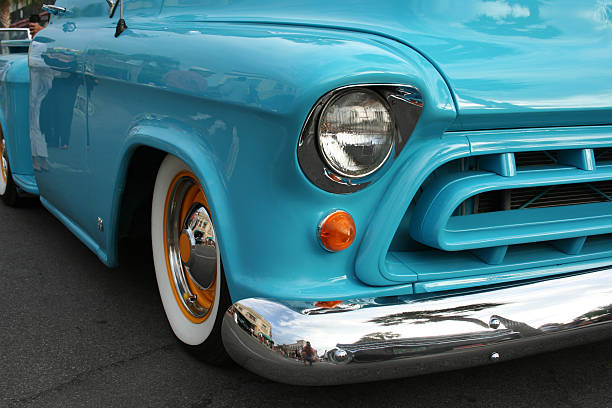 Side view of an old classic car on the street. Retro style photo of an american oldtimer pick-up from the 1960's. Vintage USA truck at sunset. Oldschool travel, traffic concept.