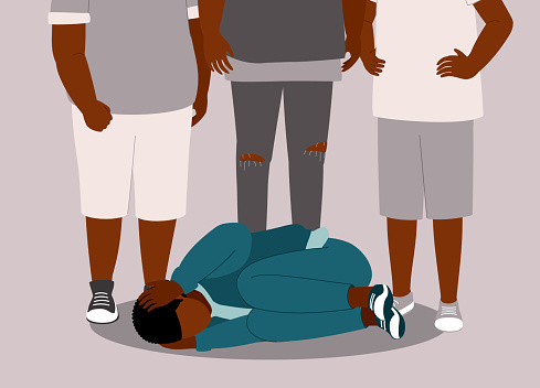 Terrified Black Teenage Boy Lying Down On Floor With Both Hands Covering His Head, Body Curl Up In Fear Of Getting Beat Up By The Three Bullies Standing Behind Him. Isolated On Color Background.