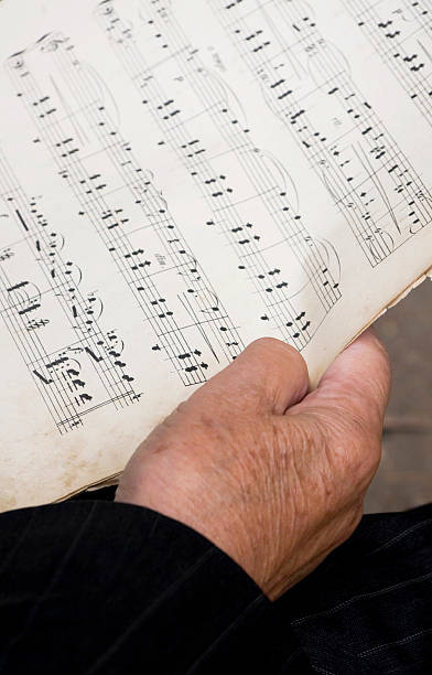 istock old hand holding sheet music 152959120