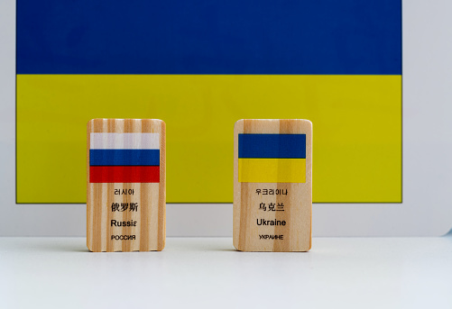 Wooden block with Ukraine and Russian flag.