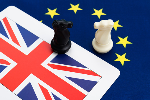 Two chess knights on European Union and UK flag.