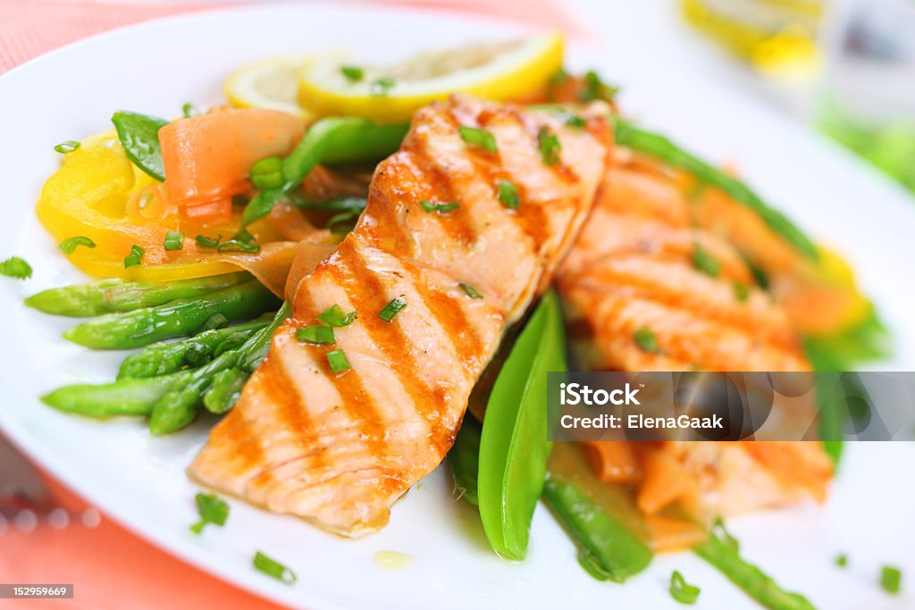 grilled salmon with spring vegetables on white plate, soft focus Asparagus Stock Photo