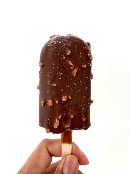 istock A hand holding delicious chocolate ice cream stick with peanuts in it, isolate on white 1529598294