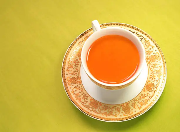 A cup of red tea on green