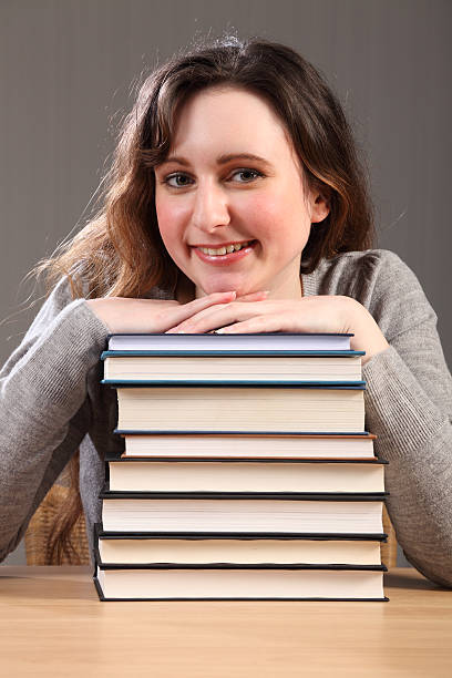 istock Beautiful happy student sitting with study books 152962110