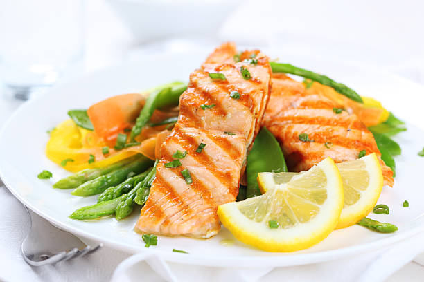 grilled salmon with asparagus  on white plate grilled salmon with asparagus, pea, yellow peppers, carrots and spring onions on white plate grilled salmon stock pictures, royalty-free photos & images