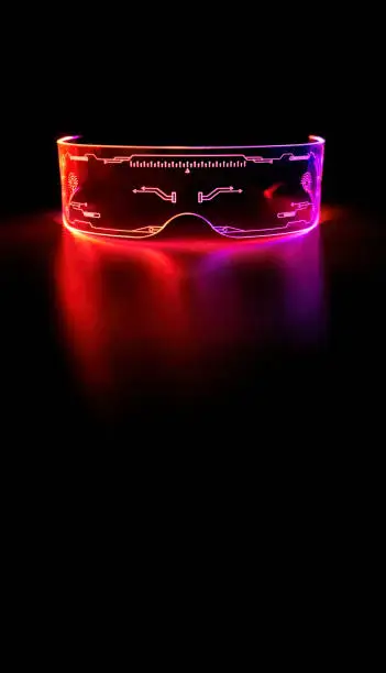 Vertical image, close up eyeware goggles colorful neon light, futuristic digital innovation concept, glow in dark background, cyber device, game head set, LED with copy space