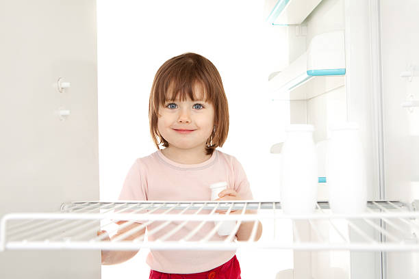 Girl looking in empty fridge stock photo