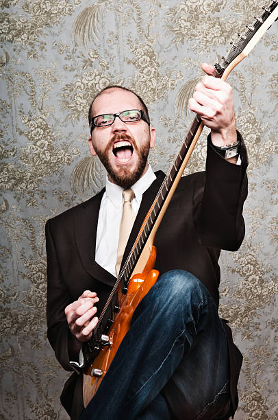 istock Rocking balding businessman holding guitar on suit 152963627