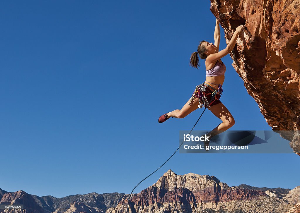 rock alpinista feminina s'agarrando às um penhasco. - Foto de stock de Escalação em rocha royalty-free
