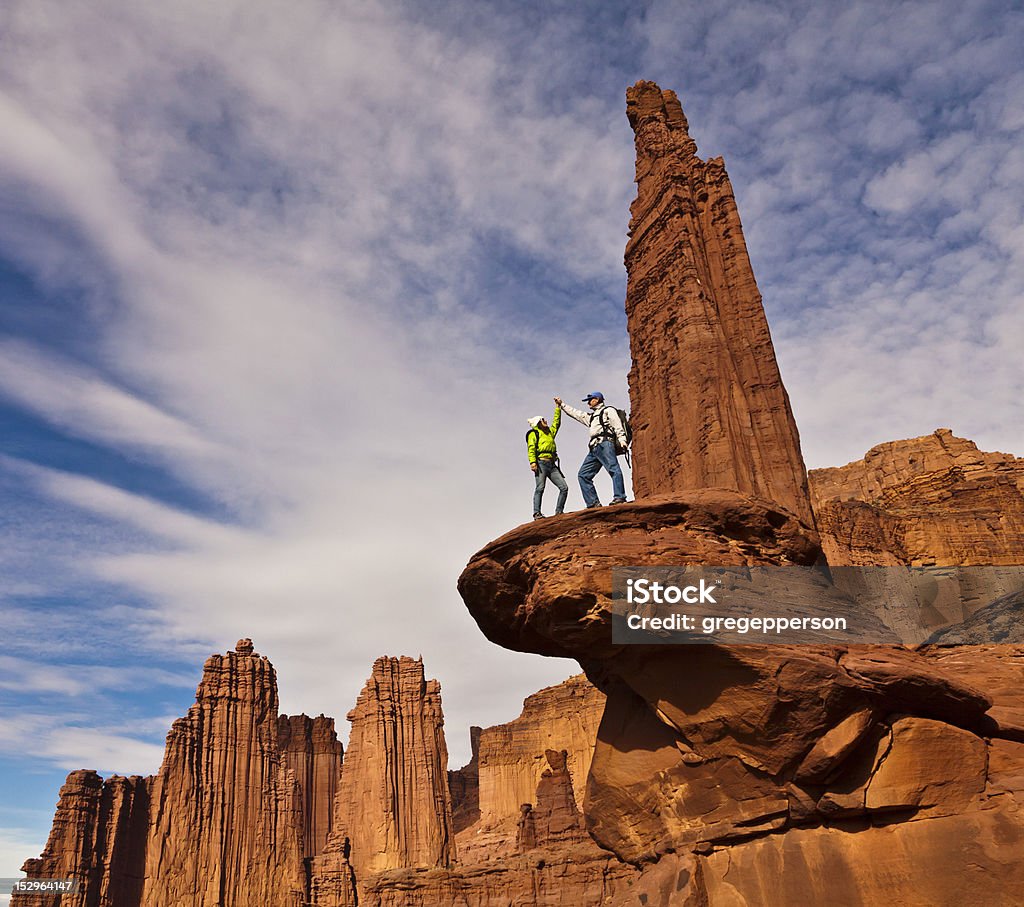 Hikers on the summit. Team of hikers on the summit of a sandstone spire in Canyonlands National Park. Achievement Stock Photo