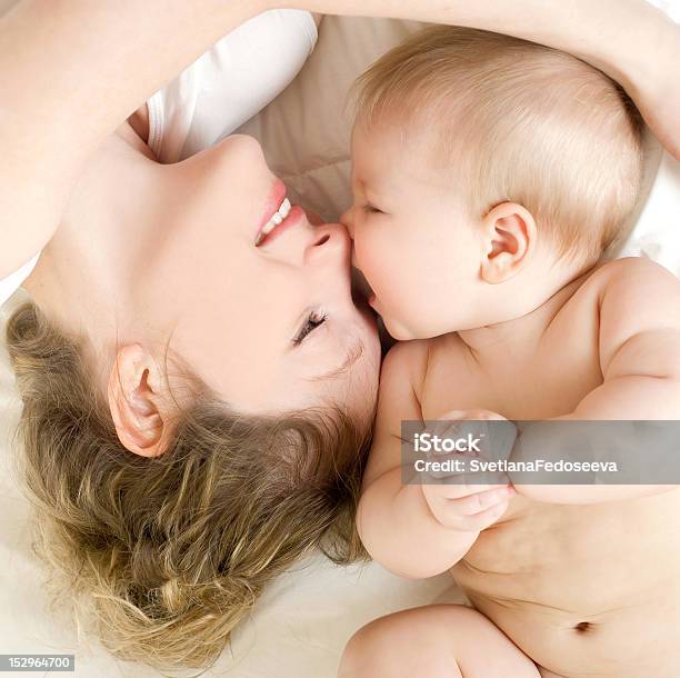 Happy Mother With Cute Baby In Bed Stock Photo - Download Image Now - Mother, Child, Embracing