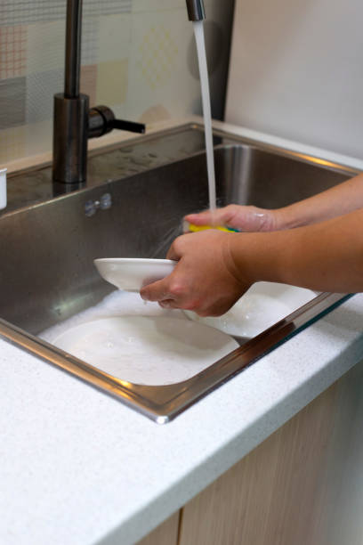 istock Man washing dish on sink in kitchen room 1529647953