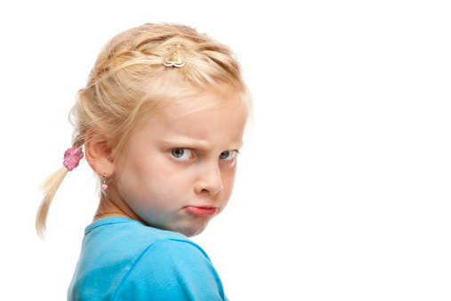 Young girl looks angry and offended in camera. Isolated on white background.