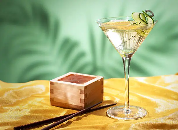 Saketini on Yellow Fabric With wooden Basin, Chopsticks and Green Fern Silhouette Background