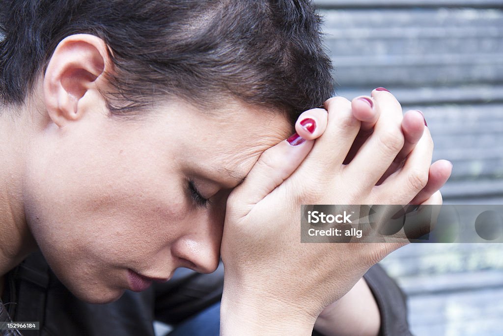 Stressed woman Closeup portrait of a stressed woman in a deep pain. Her face is pressed against her hands. Adult Stock Photo