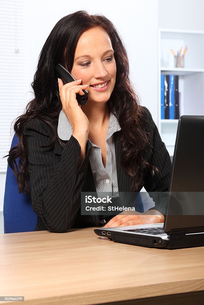 Bella donna d'affari utilizzando il telefono di lavoro - Foto stock royalty-free di Computer portatile