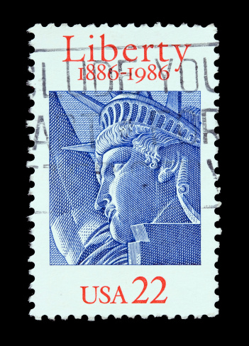 USA 22 cent postal stamp with the Statue of Liberty in blue and with the sentence \