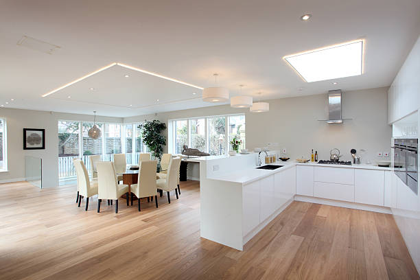 Modern kitchen in white with a hardwood floor Kitchen and dining area open plan stock pictures, royalty-free photos & images