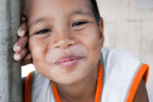 Portrait of a smiling boy in the Philippines from an impoverished neighborhood.
