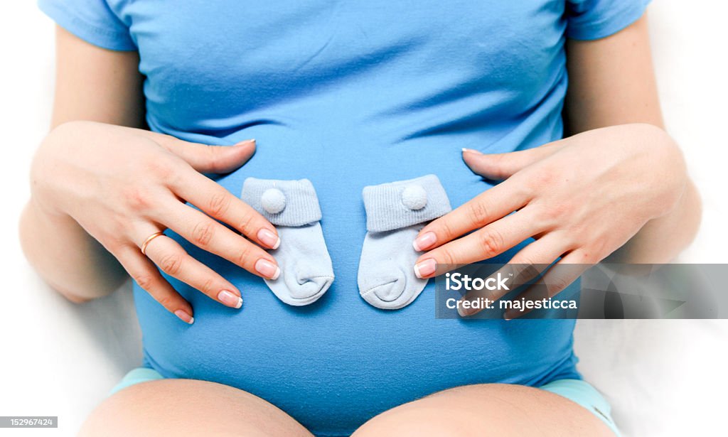 Mujer embarazada con poco calcetines - Foto de stock de Abdomen libre de derechos