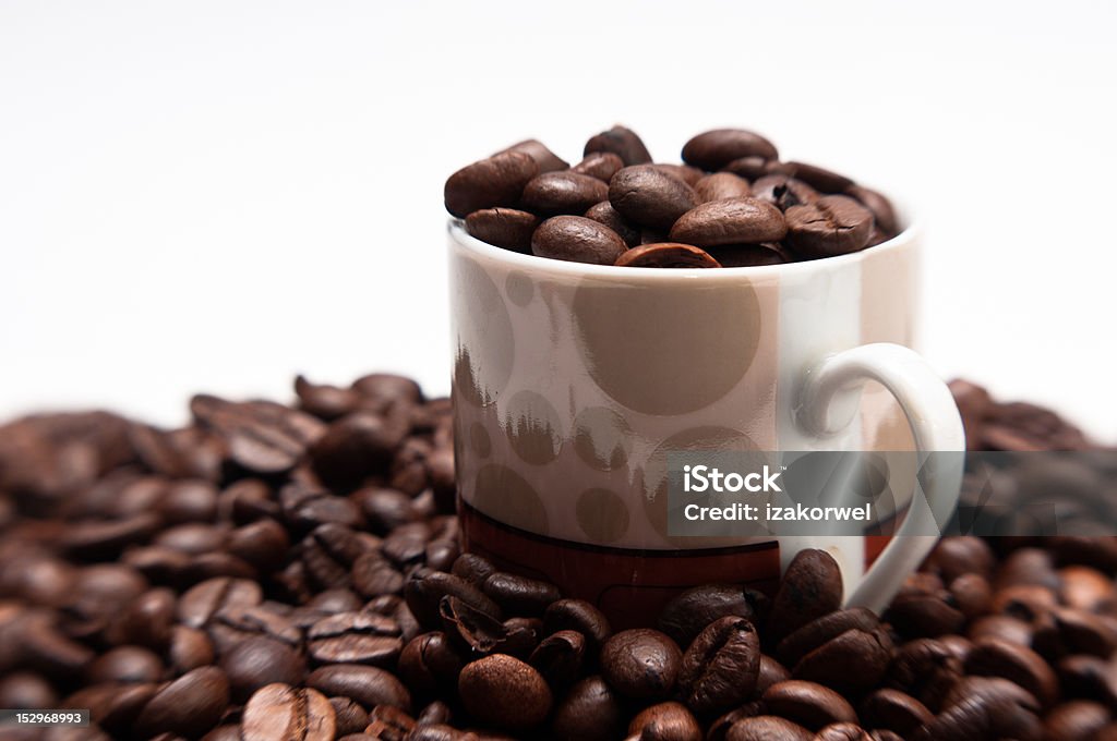Cup and roasted coffeee beans Cup of coffee beans surrounded with roasted beans on white, isolating background Black Color Stock Photo