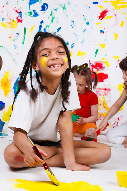 A cheerful African American girl painting