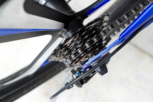 A close-up shows the rear sprocket and chain on a kids' mountain bike for exercise.