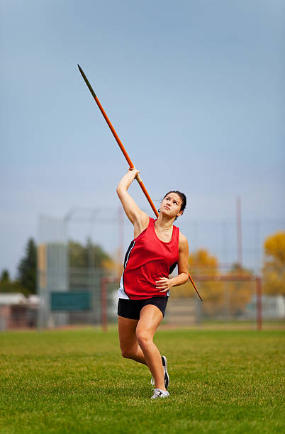 Javelin A young, female athlete throwing a javelin in a track and field event. womens field event stock pictures, royalty-free photos & images