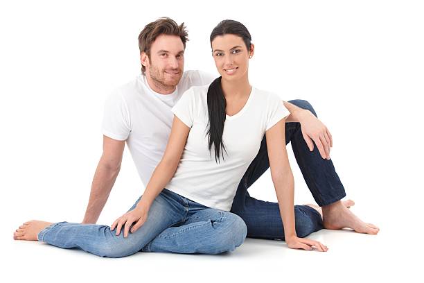 Attractive loving couple sitting on floor smiling stock photo