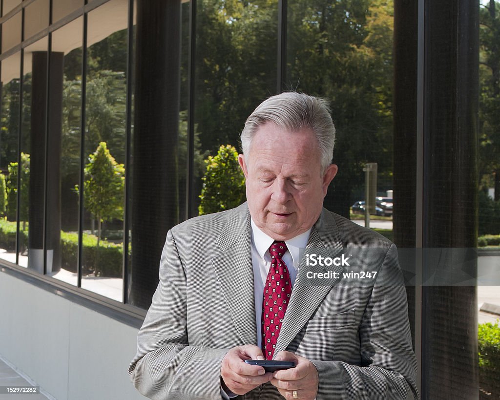 Biznes człowiek Wysyłanie SMS-ów na zewnątrz w letni dzień w biurze - Zbiór zdjęć royalty-free (60-64 lata)