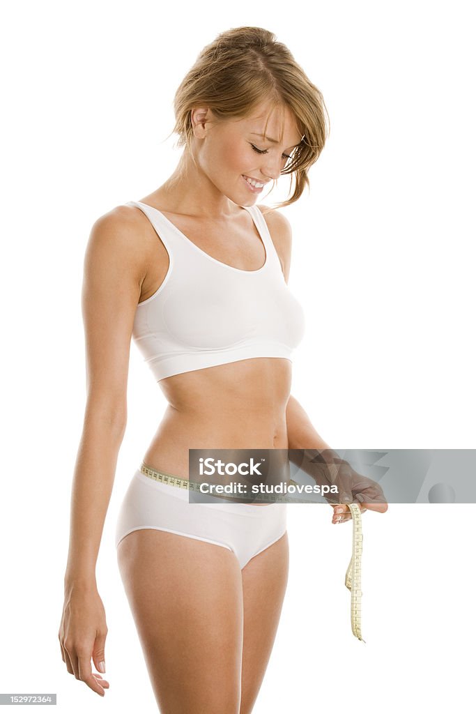Young woman in underwear measuring her waist Woman in lingerie measuring waist 20-24 Years Stock Photo