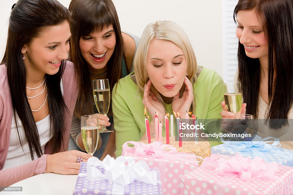 Urodziny party-kobieta dmuchającego świeczki na tort - Zbiór zdjęć royalty-free (Alkohol - napój)