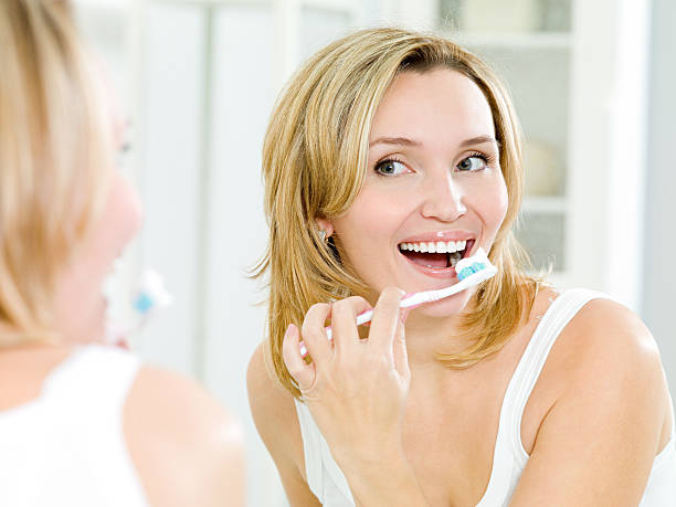 istock Happy woman brushing her teeth with toothbrush 152974407