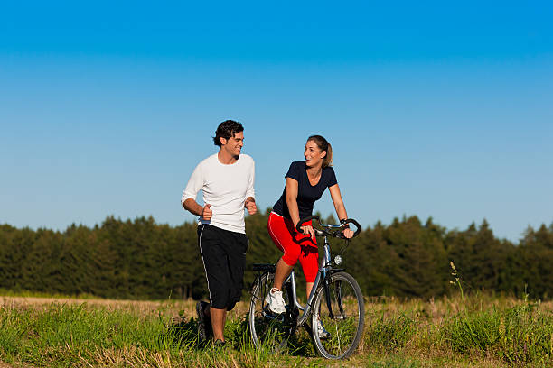 hombre y mujer con bicicleta para trotar - riding autumn meadow land fotografías e imágenes de stock