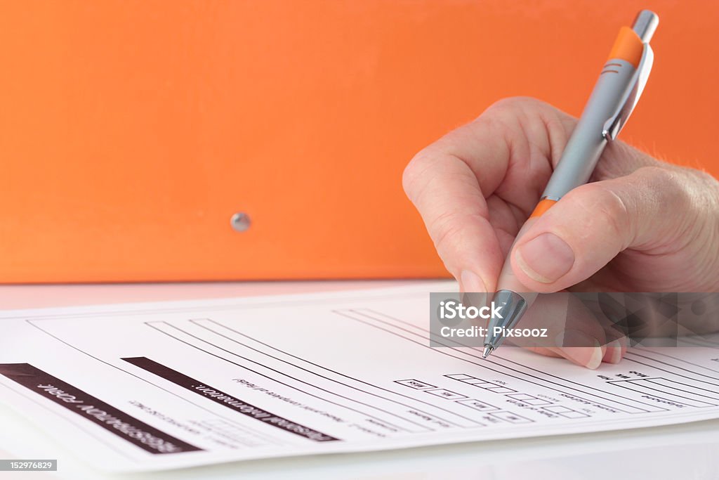 Orange Themen-Stift in der Hand ausfüllen Formular - Lizenzfrei Unterschreiben Stock-Foto