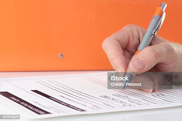 Naranja Con Lápiz En Las Manos De Completar El Formulario Foto de stock y más banco de imágenes de Firmar