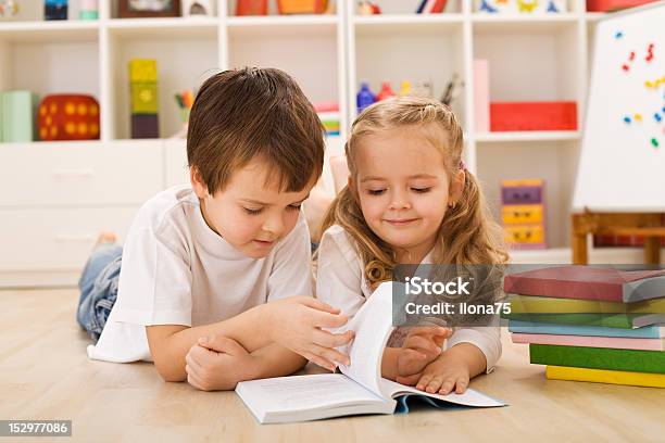 Scuola Ragazzo Insegnando E Mostrando La Sua Sorella Come Leggere - Fotografie stock e altre immagini di Allegro