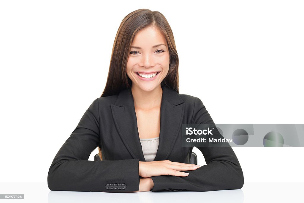 Multiethnic businesswoman sitting at desk smiling Multi ethnic businesswoman smiling sitting at her desk. Beautiful young model isolated on white background. White Background Stock Photo