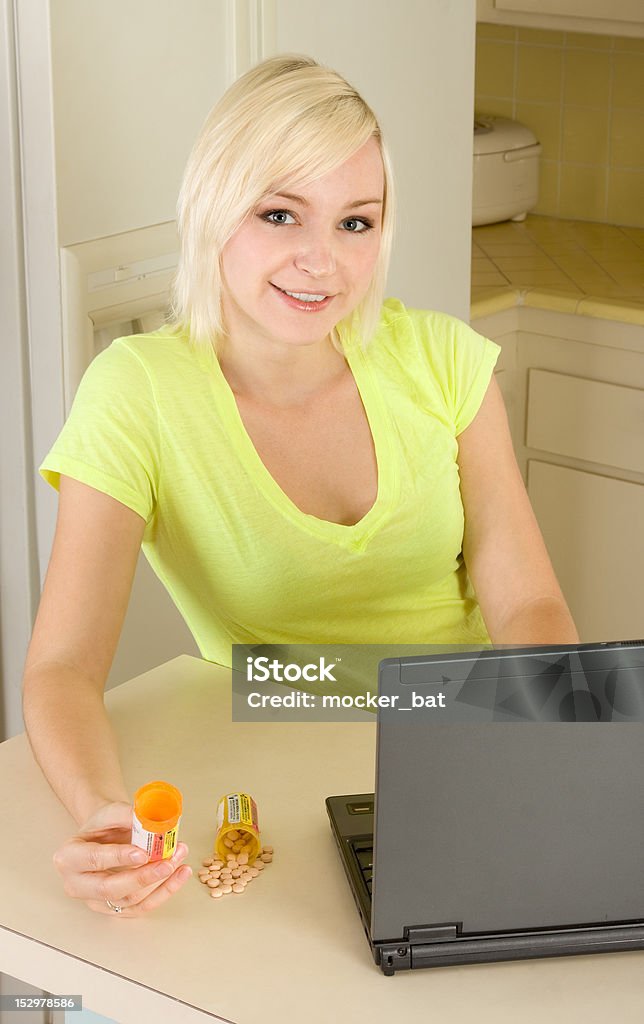 Jeune femme blonde avec des médicaments par ordinateur - Photo de 16-17 ans libre de droits