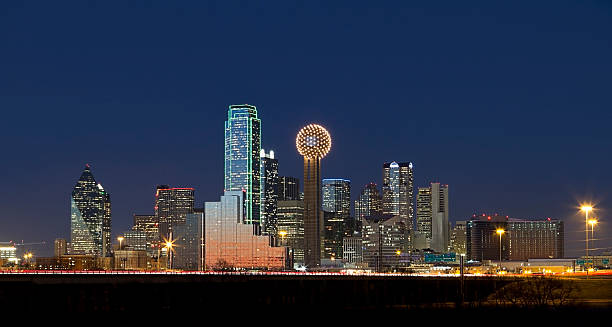 Dallas, Texas Skyline at Night Panoramic shot of Dallas, Texas business district showcasing skyscrapers glowing and lights glimmering at night. reunion tower photos stock pictures, royalty-free photos & images