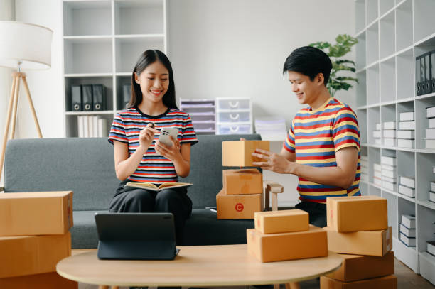 istock Starting small businesses SME owners, two check online orders Selling products working with boxs freelance work  on sofa at home using tablet and laptop  marketing, packaging, concept 1529802417