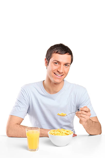 istock Smiling young man eating cornflakes at breakfast 152980419