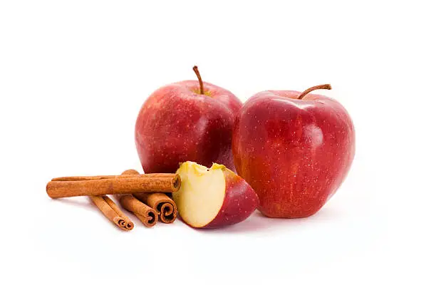 red apples and cinnamon isolated on white background