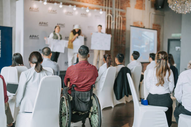 istock Team building asian group presenting ideas in front of all workshop participants in APAC business conference discussion 1529813444