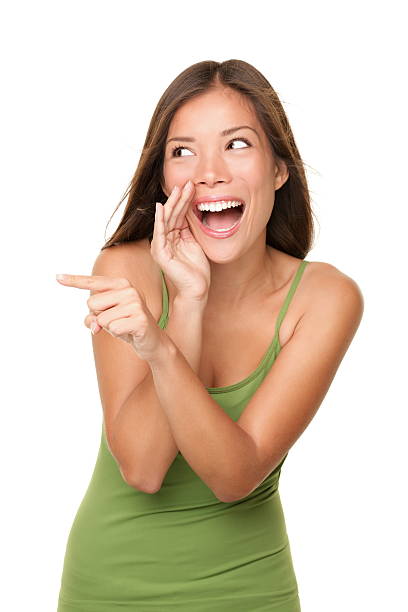 Woman laughing and pointing at someone. Funny dynamic isolated waist up portrait of gorgeous mixed race Asian Caucasian female model. For more: