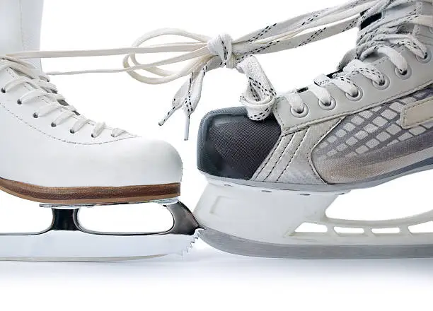 Skate for figure skating and  hockey skate tied against each other close up isolated on white background