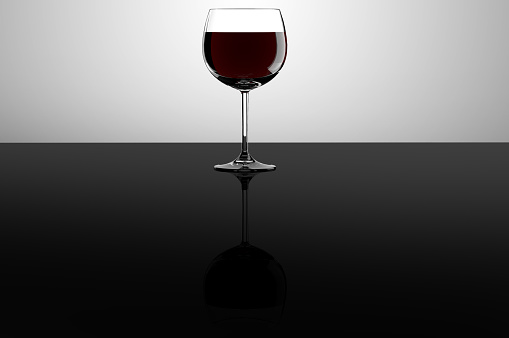Red wine glass on a reflective surface