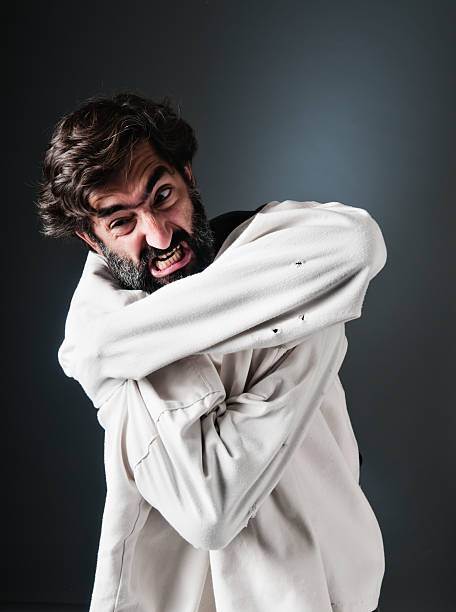 Furious man trying to scape from straitjacket stock photo